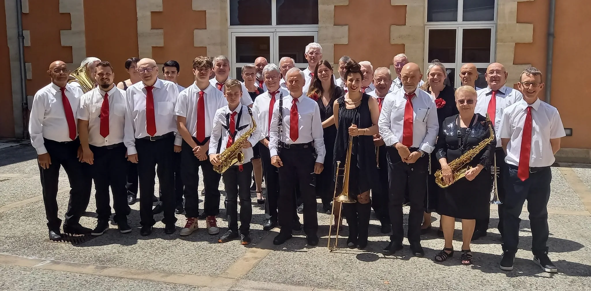 Les musiciens de l'harmonie souriant à la caméra
